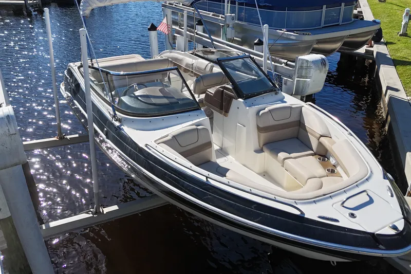Slide: The Image of 2014 Formula 240 Bowrider boat docked on a sunny day, showcasing sleek design and spacious seating. - 13