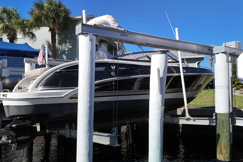 Slide: The Image of 2014 Formula 240 Bowrider boat on lift, sunny day, palm trees in background. - 16