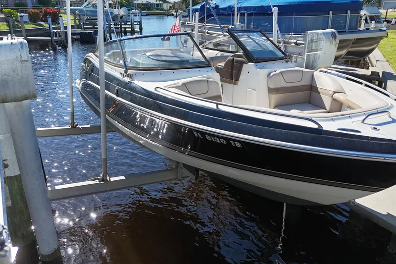 Slide: The Image of 2014 Formula 240 Bowrider boat on lift by dock, sunny day. - 19