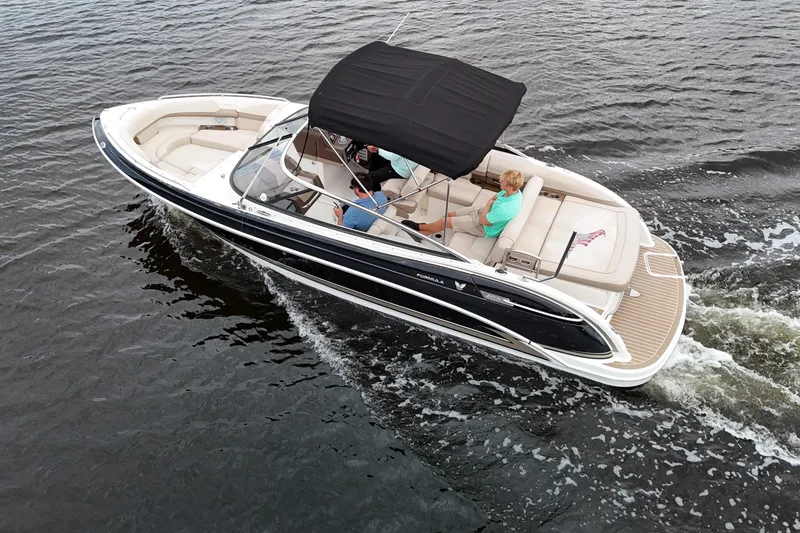 Slide: The Image of 2014 Formula 240 Bowrider cruising on water with passengers under a black canopy. - 2