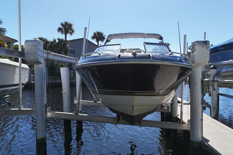 Slide: The Image of 2014 Formula 240 Bowrider boat on lift, docked near waterfront homes. - 20