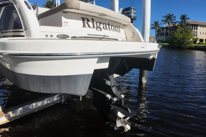 Slide: The Image of 2014 Formula 240 Bowrider boat named "Rigatoni" docked by waterfront homes. - 23