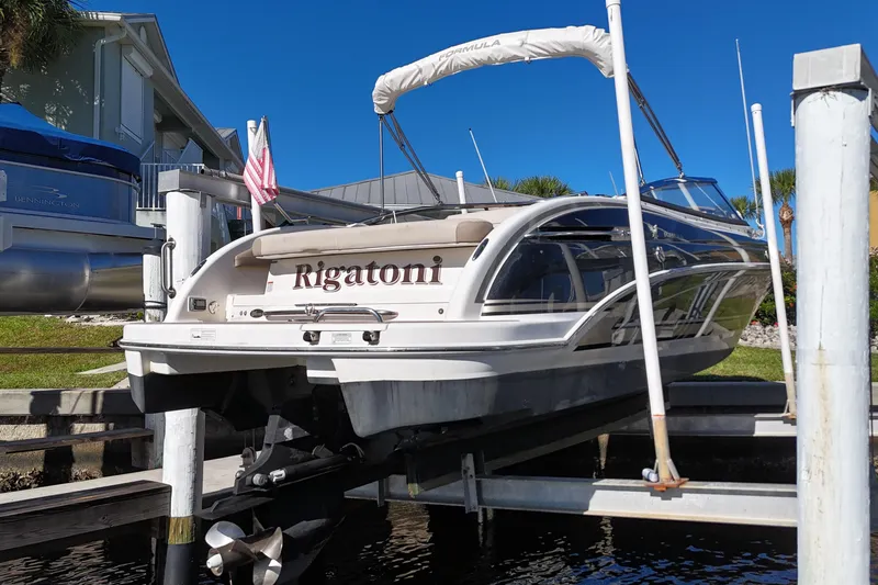Slide: The Image of 2014 Formula 240 Bowrider boat named "Rigatoni" docked on a lift, sunny day. - 24