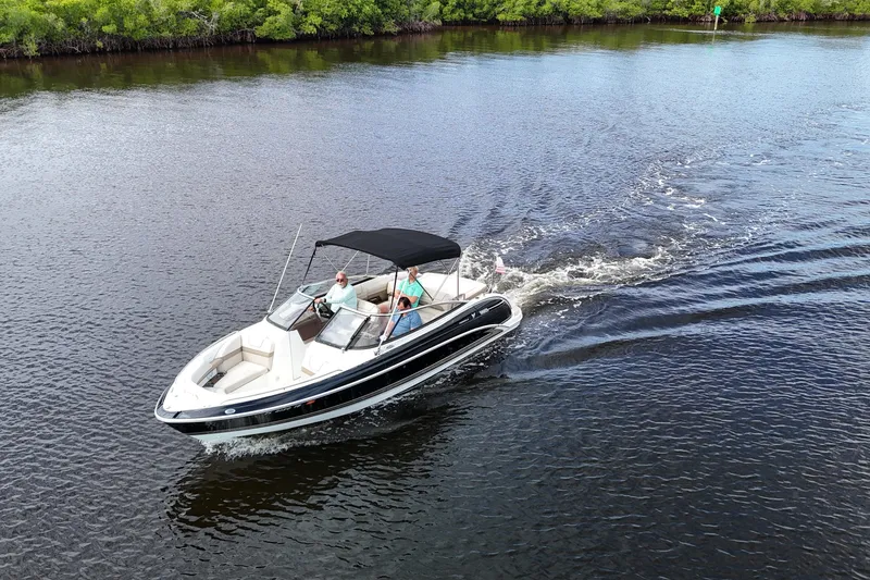 Slide: The Image of 2014 Formula 240 Bowrider cruising on a calm river with lush greenery. - 4