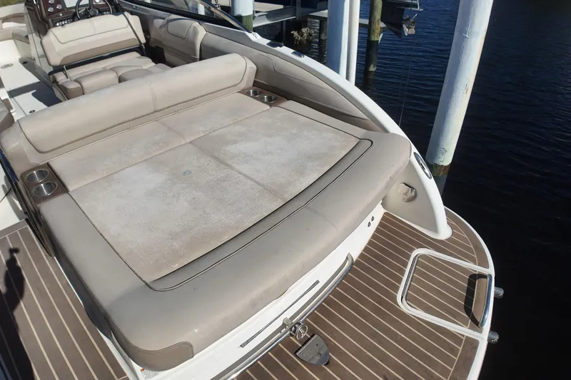 Slide: The Image of 2014 Formula 240 Bowrider boat with spacious sunpad and cup holders, docked by the water. - 41