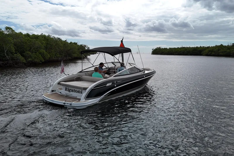 Slide: The Image of 2014 Formula 240 Bowrider boat cruising on a scenic waterway under cloudy skies. - 46