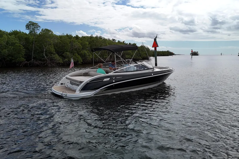 Slide: The Image of 2014 Formula 240 Bowrider cruising on a calm waterway with lush greenery. - 47