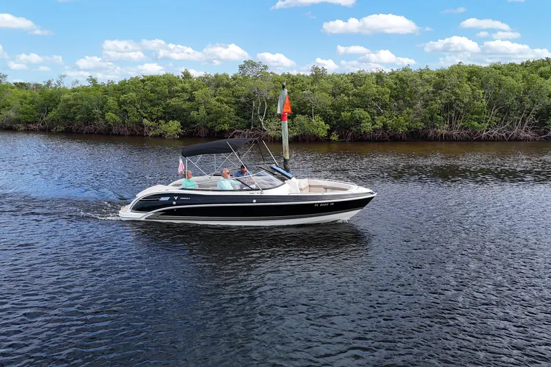 Slide: The Image of 2014 Formula 240 Bowrider cruising on a scenic river with lush greenery. - 48
