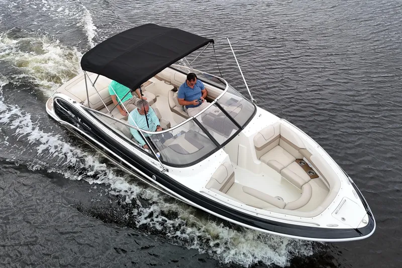 Slide: The Image of 2014 Formula 240 Bowrider cruising on water with passengers under a black canopy. - 5