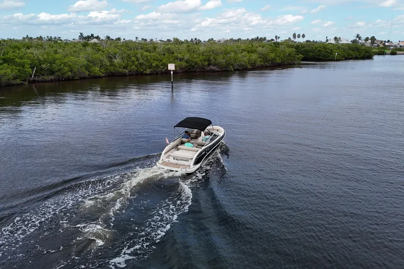 Slide: The Image of 2014 Formula 240 Bowrider cruising on a serene river with lush greenery. - 52