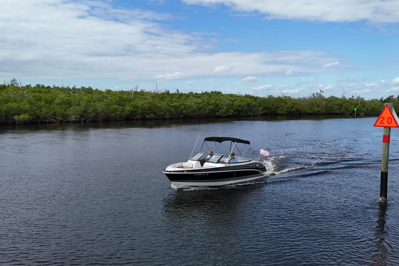 Slide: The Image of 2014 Formula 240 Bowrider cruising on a calm river under a partly cloudy sky. - 57
