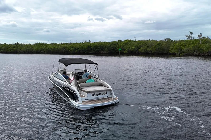 Slide: The Image of 2014 Formula 240 Bowrider boat cruising on a calm river with lush greenery. - 8