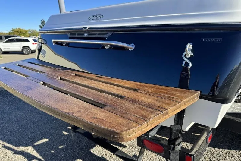 Slide: The Image of 1999 Tigé 2100V Limited boat with wooden swim platform, parked outdoors. - 15