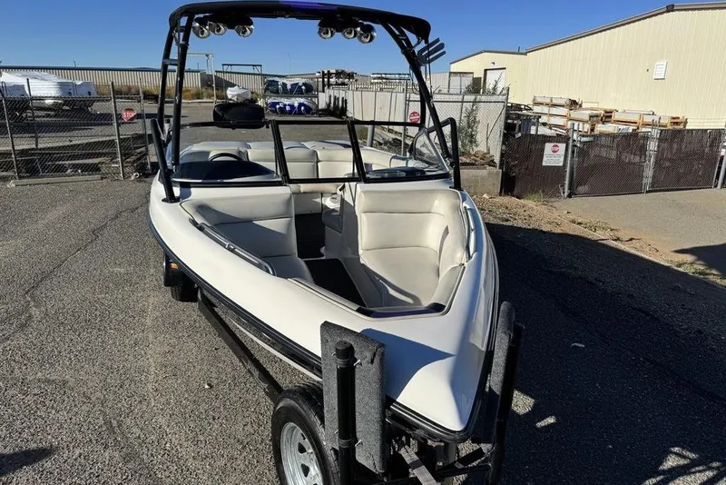Slide: The Image of 1999 Tigé 2100V Limited boat on trailer, parked outdoors. - 2