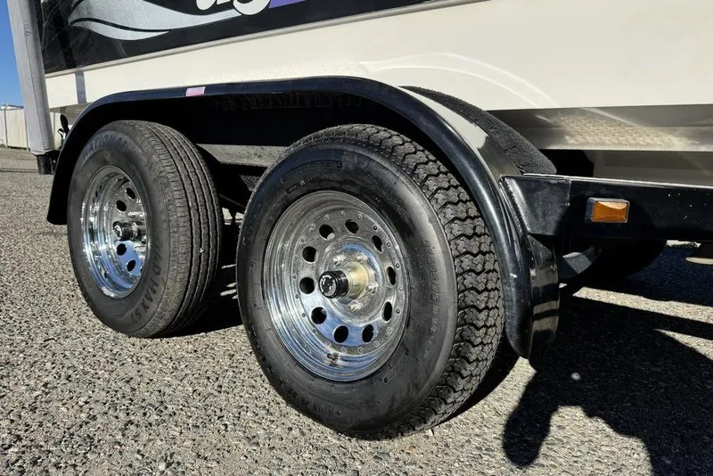 Slide: The Image of Trailer wheels of a 1999 Tigé 2100V Limited boat on a sunny day. - 3