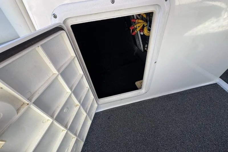 Slide: The Image of Open storage compartment on a 1999 Tigé 2100V Limited boat, showing interior wiring. - 39