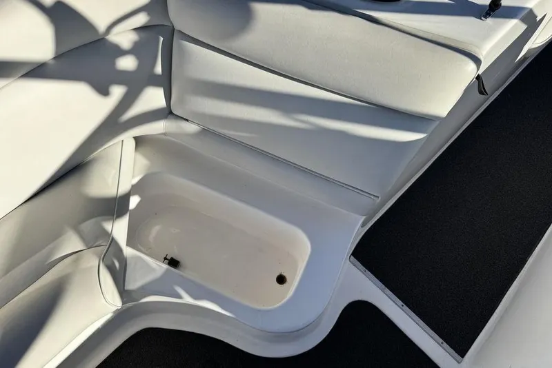 Slide: The Image of Interior of a 1999 Tigé 2100V Limited boat, featuring white seating and flooring. - 54