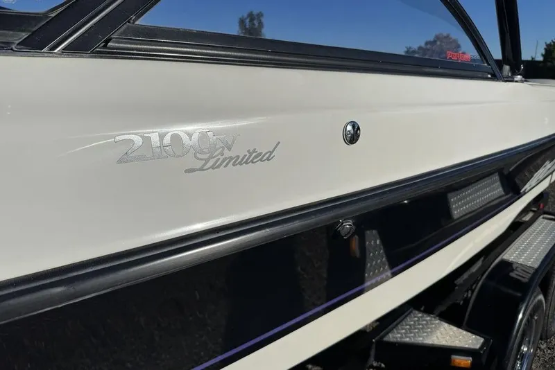 Slide: The Image of 1999 Tigé 2100V Limited boat side view with logo and trailer. - 60