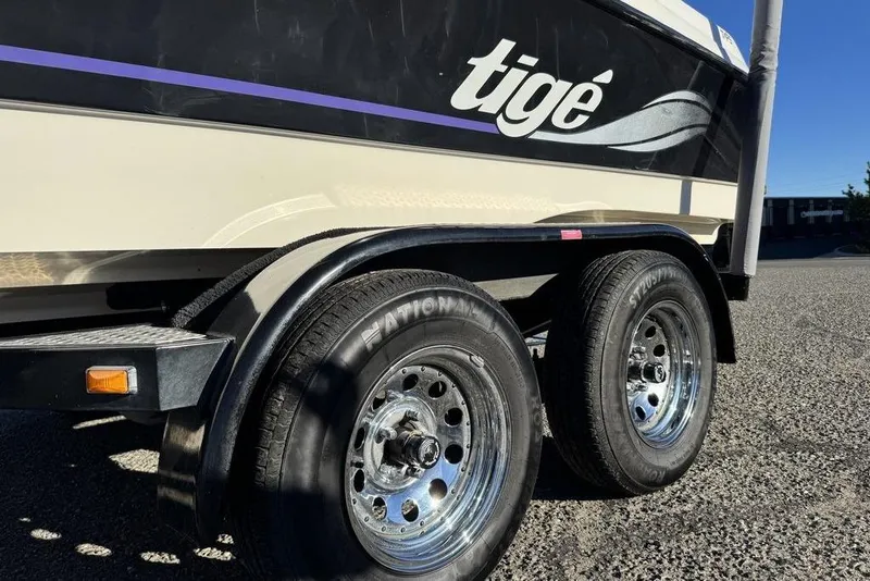 Slide: The Image of 1999 Tigé 2100V Limited boat trailer with dual wheels on a sunny day. - 62