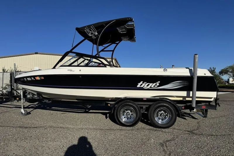Slide: The Image of 1999 Tigé 2100V Limited boat on trailer, black and white design, sunny day. - 65