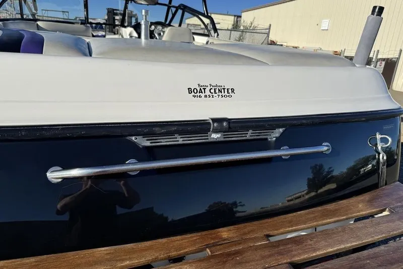 Slide: The Image of 1999 Tigé 2100V Limited boat at showroom, rear view with branding details. - 68