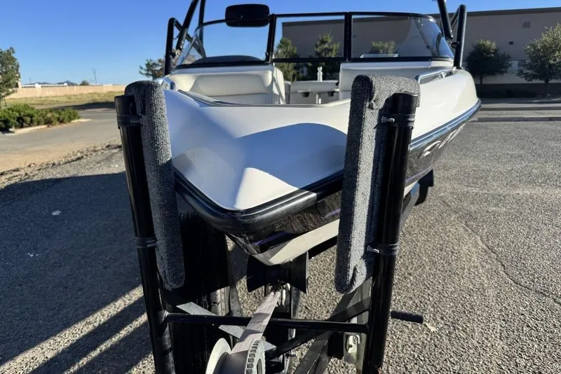 Slide: The Image of 1999 Tigé 2100V Limited boat on trailer, parked outdoors under clear sky. - 75