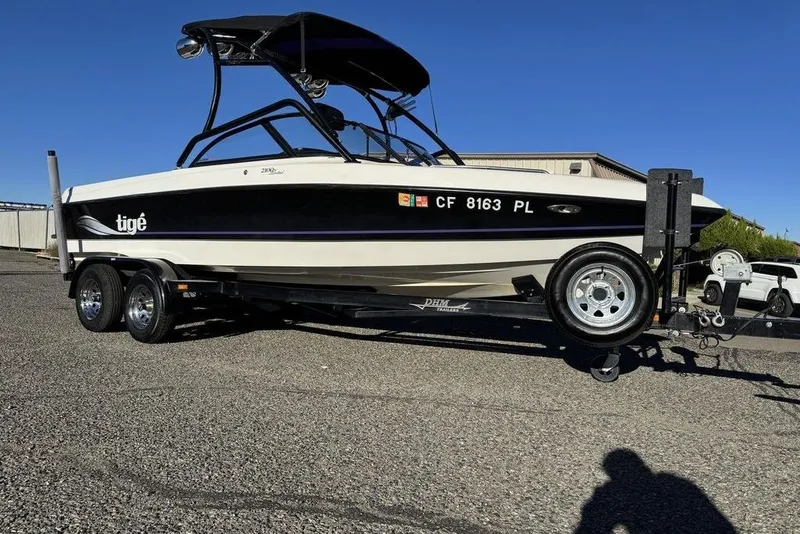Slide: The Image of 1999 Tigé 2100V Limited boat on trailer, parked outdoors under clear blue sky. - 78