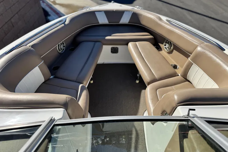 Slide: The Image of 2007 Cobalt 252 boat interior with brown and white seating, featuring cup holders and speakers. - 13