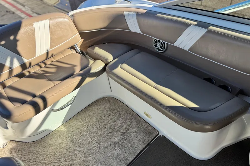 Slide: The Image of 2007 Cobalt 252 boat interior with brown and white seating, cup holders, and carpeted floor. - 24