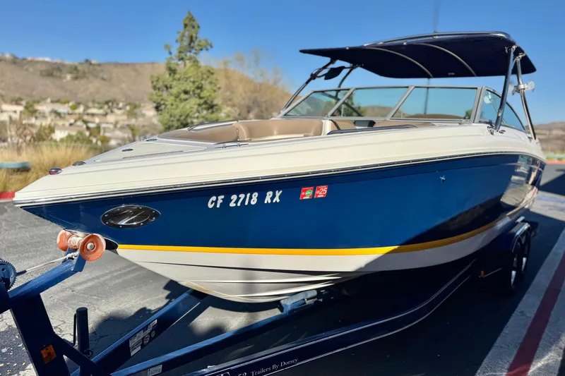 Slide: The Image of 2007 Cobalt 252 boat on trailer, blue and white exterior, parked outdoors. - 3