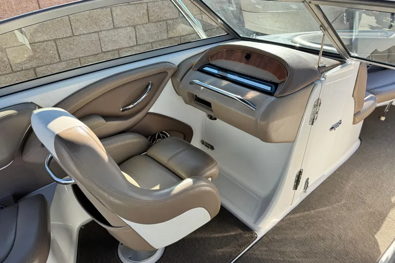 Slide: The Image of Interior of a 2007 Cobalt 252 boat, featuring brown leather seating and dashboard. - 32