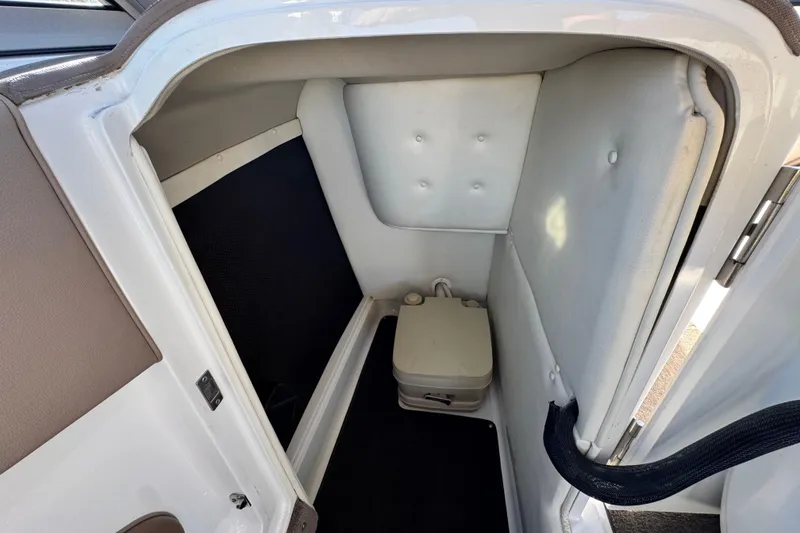 Slide: The Image of 2007 Cobalt 252 boat interior with compact marine toilet and cushioned walls. - 35