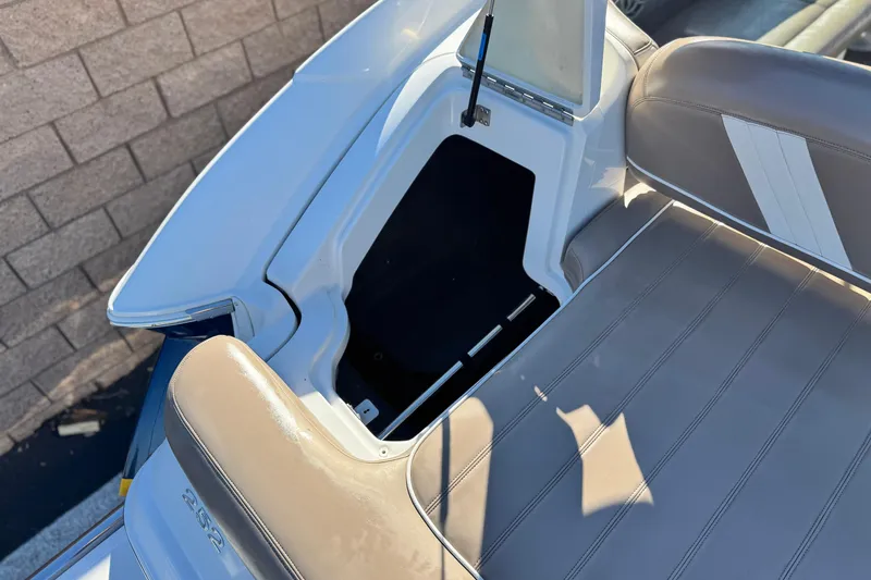Slide: The Image of 2007 Cobalt 252 boat interior with open storage compartment and beige seating. - 7