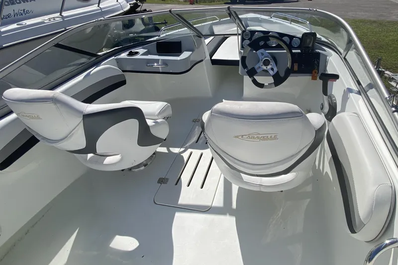 Slide: The Image of Interior of a 2016 Caravelle 16 EBo boat with white seating and steering console. - 5