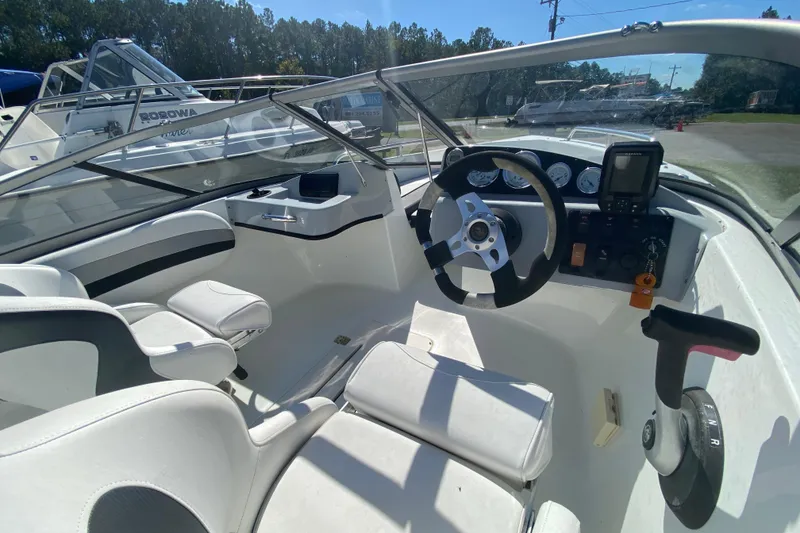 Slide: The Image of Interior of a 2016 Caravelle 16 EBo boat with steering wheel and seating. - 11