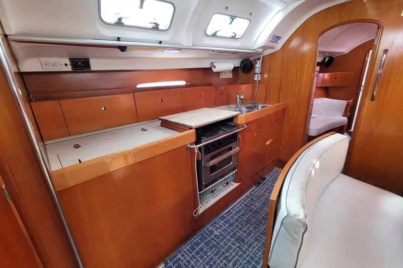 Slide: The Image of Interior of 1996 Beneteau First 42s7 yacht with wood finish and white seating. - 31