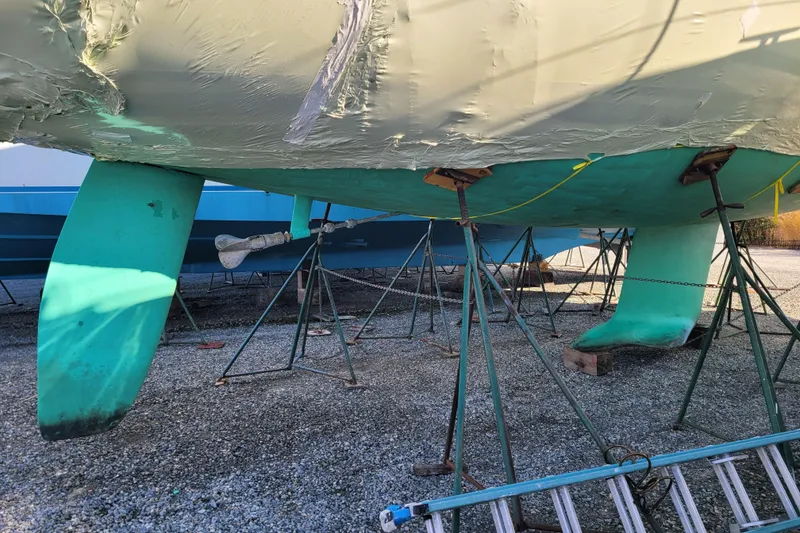 Slide: The Image of 1996 Beneteau First 42s7 sailboat on stands, showing hull and keel. - 74