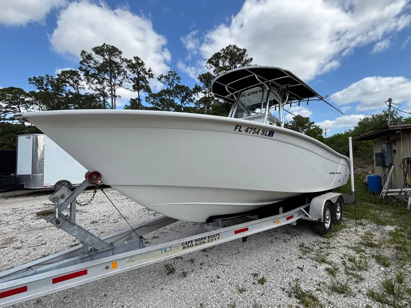 Slide: The Image of 2019 Cape Horn 24 OS boat on trailer, parked outdoors under a cloudy sky. - 1