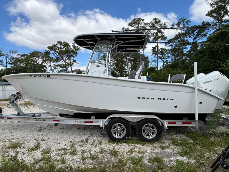 Slide: The Image of 2019 Cape Horn 24 OS boat on trailer, white hull, dual Mercury engines, outdoor setting. - 10