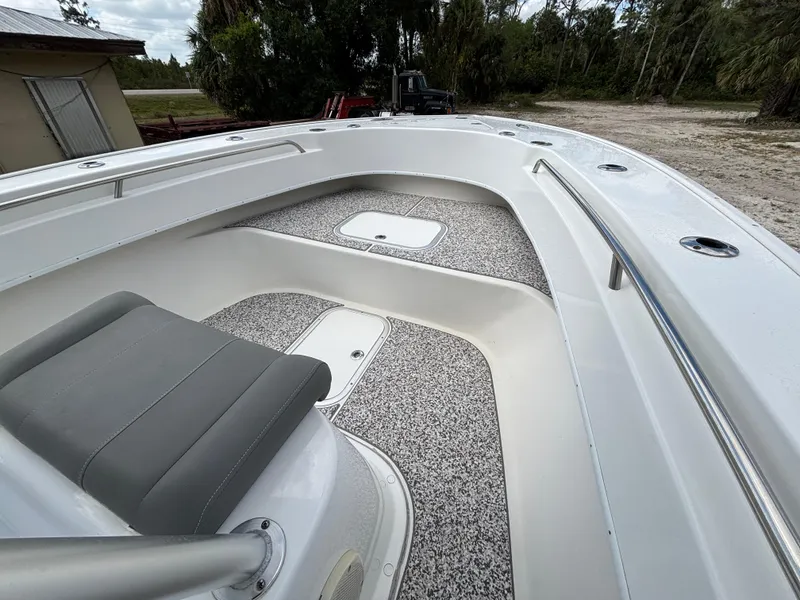 Slide: The Image of 2019 Cape Horn 24 OS boat interior with seating and storage, surrounded by lush greenery. - 16