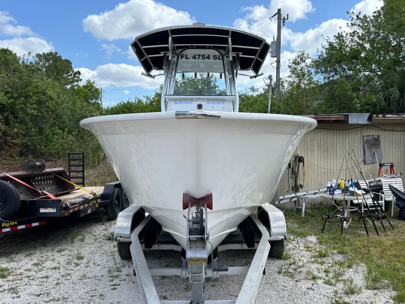 Slide: The Image of 2019 Cape Horn 24 OS boat on trailer, surrounded by trees and equipment. - 3