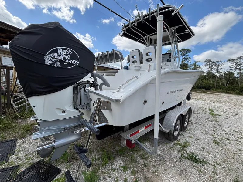 Slide: The Image of 2019 Cape Horn 24 OS boat on trailer, featuring dual engines and T-top, parked outdoors. - 6