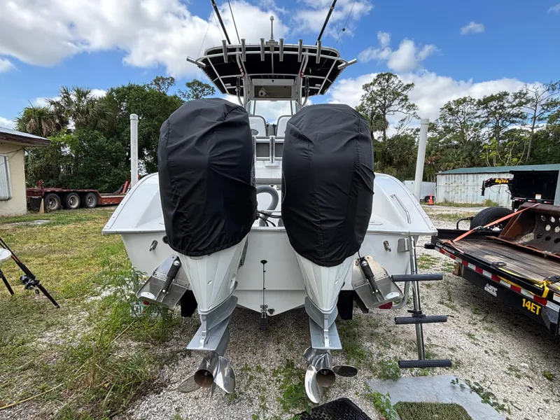 Slide: The Image of 2019 Cape Horn 24 OS boat with dual covered outboard motors, parked outdoors. - 7