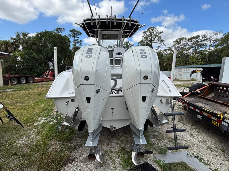 Slide: The Image of 2019 Cape Horn 24 OS boat with dual outboard engines, parked on a grassy area. - 9