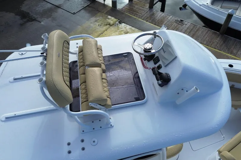Slide: The Image of 2021 Sportsman Heritage 251 Center Console boat helm with beige seating and steering wheel. - 10
