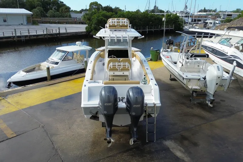 Slide: The Image of 2021 Sportsman Heritage 251 Center Console boat with dual engines at a marina. - 12