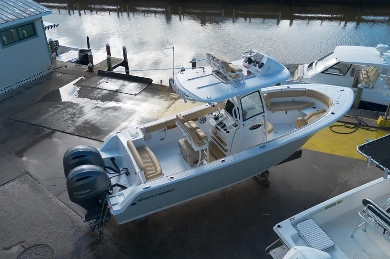 Slide: The Image of 2021 Sportsman Heritage 251 Center Console boat docked, featuring dual Yamaha engines. - 6