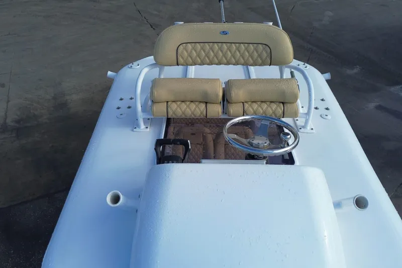 Slide: The Image of 2021 Sportsman Heritage 251 Center Console boat with beige seating and steering wheel. - 9