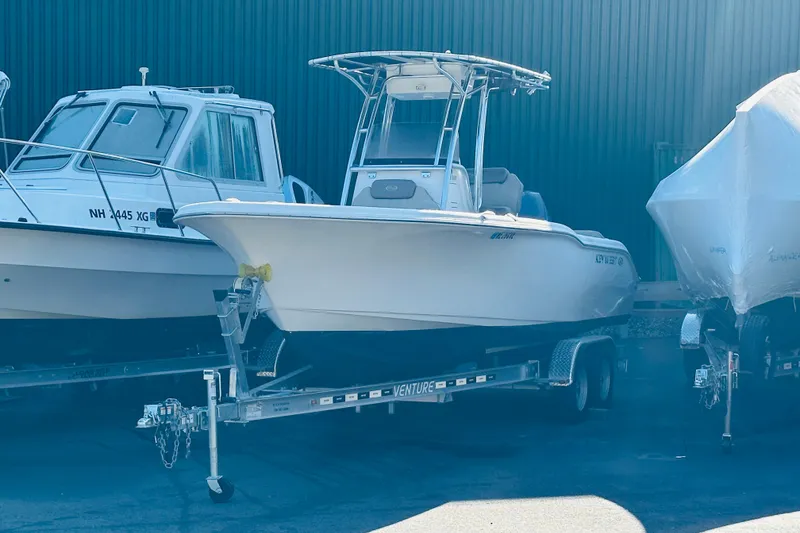 The Image of 2022 Key West 239 FS boat on trailer, parked between other boats. - 0