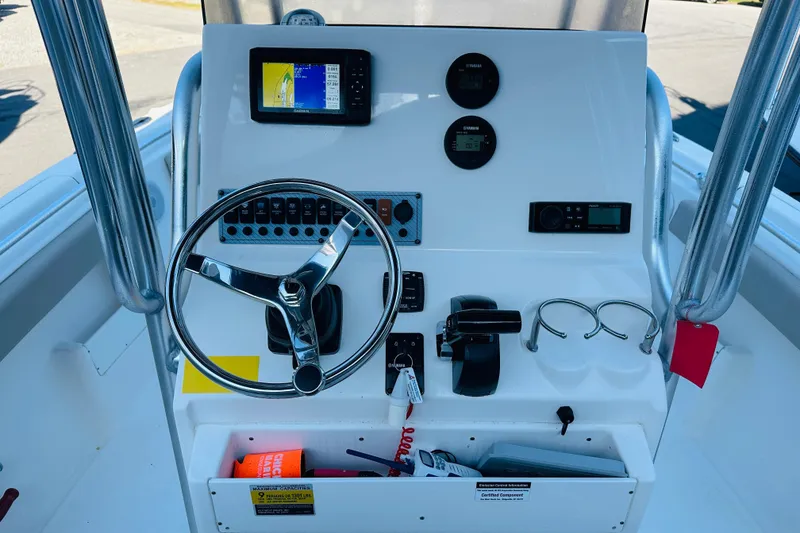 Slide: The Image of 2022 Key West 239 FS boat dashboard with steering wheel and navigation controls. - 10